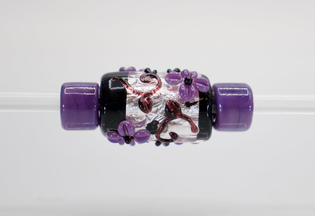 a close up of a purple and black bead