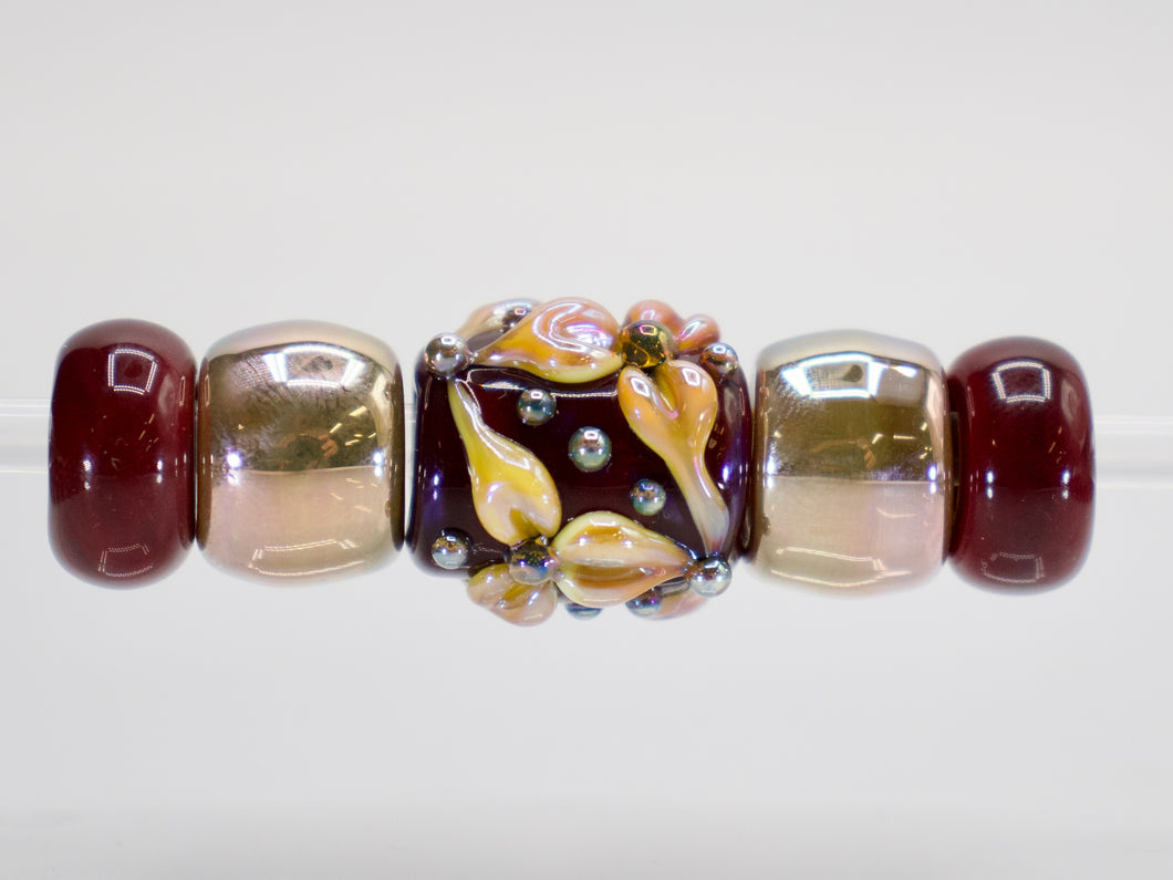 a beaded bracelet with a flower design on it